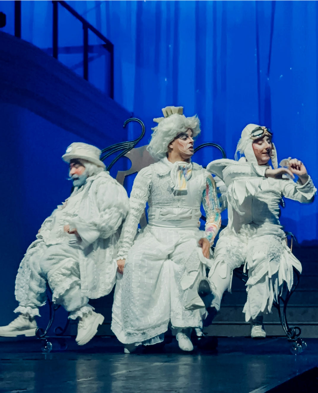 Three people in costumes on stage