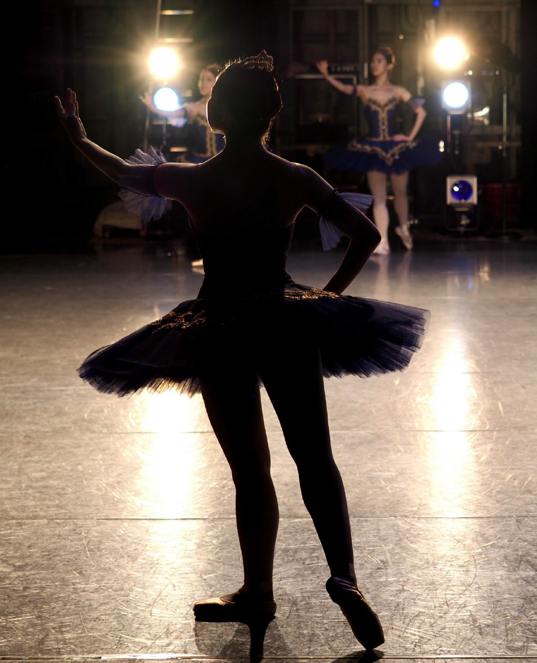 A ballerina silhouetted by spotlights